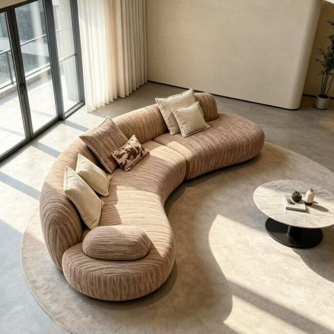 STANDEE's Modern Curved Sectional Sofa is an Italian-inspired contemporary sofa featuring a sculptural curved silhouette, deep comfortable seating, textured fabric upholstery, and a warm neutral finish, designed for modern and luxury living spaces.